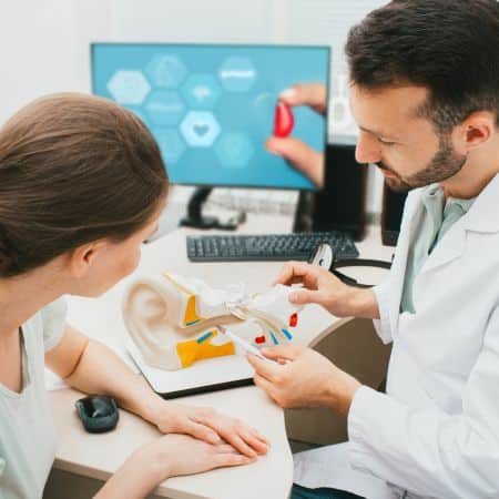 audiologist showing patient a diagram of an ear