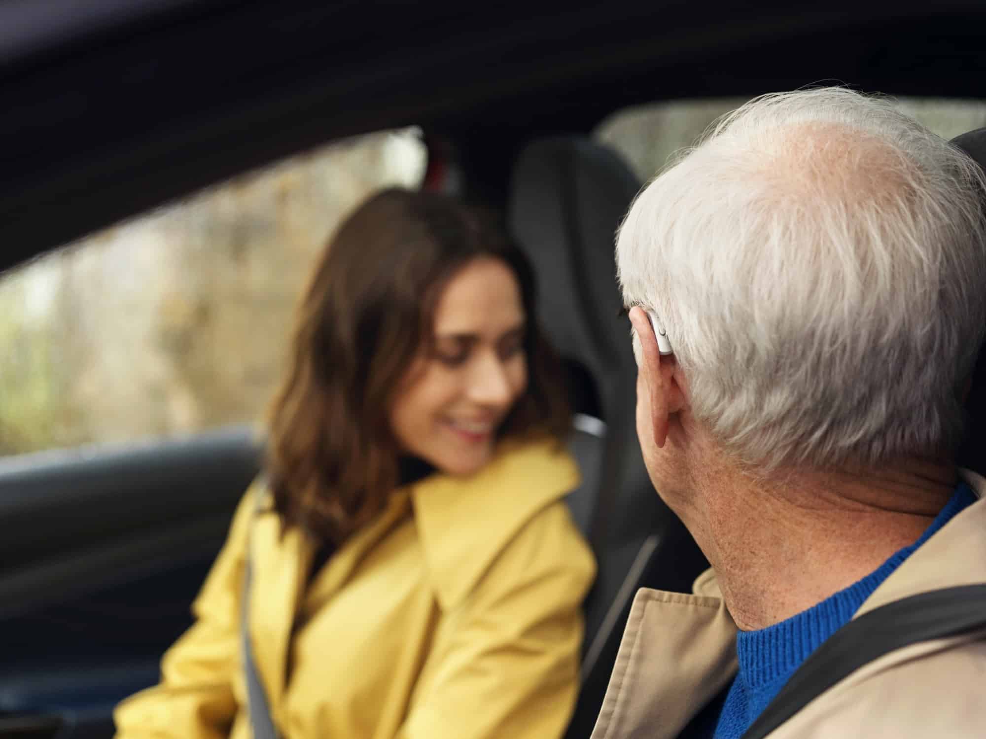 a man in a car looks into his backseat next to his daughter