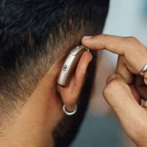 man adjusting his hearing aid