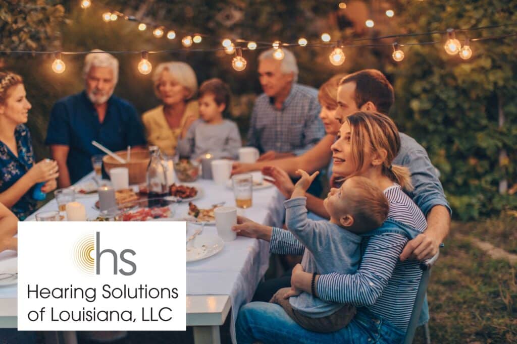 family sitting at a picnic table having dinner