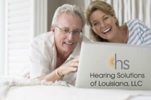 older couple smiling and looking at a laptop