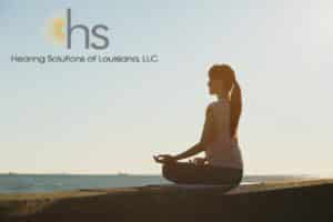 woman doing yoga by the ocean