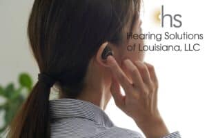 woman touching her hearing aid